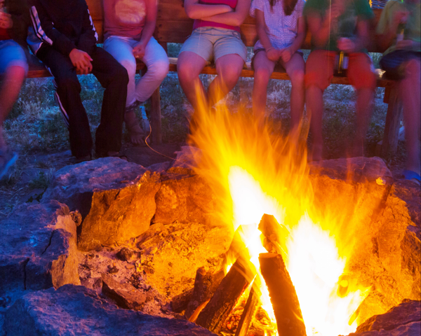 People sitting in front of campfire